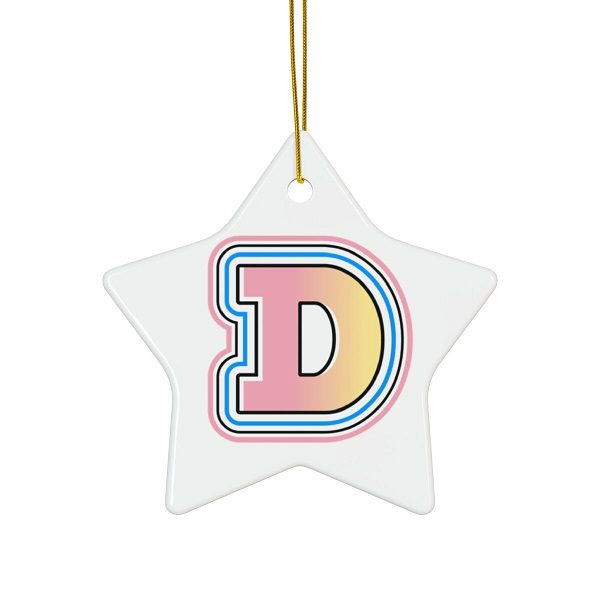 White, star-shaped ceramic Christmas ornament hanging from a gold string, featuring a large, stylized Doge 'D' logo in a pink, yellow, and blue gradient outline.